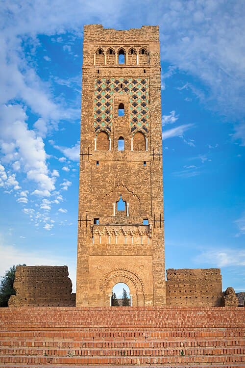 The stone minaret of the Mansourah mosque in Tlemcen against a blue sky